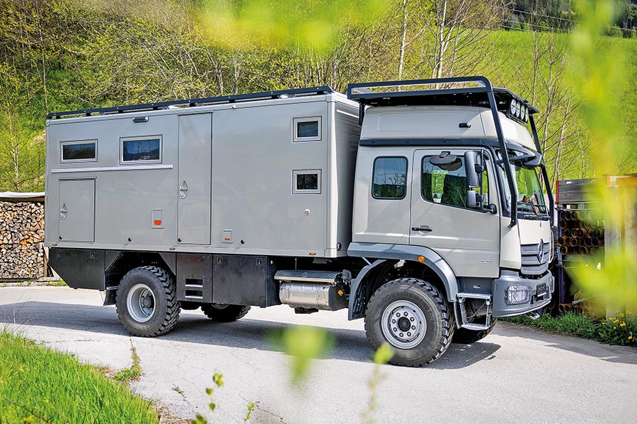 Großer, hellgrauer Expeditions-LKW Krug Expedition Project Rhino Family XL auf Basis des MB Atego auf Landstraße