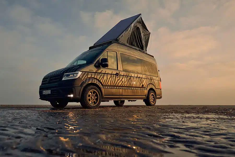 Dunkler VW Crafter Campervan mit Aufstelldach am Wasser