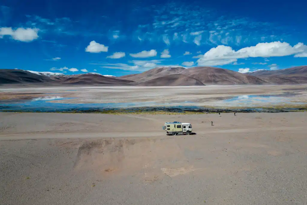 Expeditionsfahrzeug vor Lagune mit unzähligen Flamingos