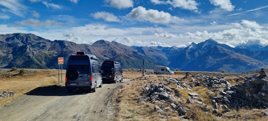 Zwei Campervans auf einer Bergstraße, im Hintergrund kahle Berge