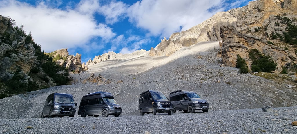 Vier Campervans in karger Berglandschaft