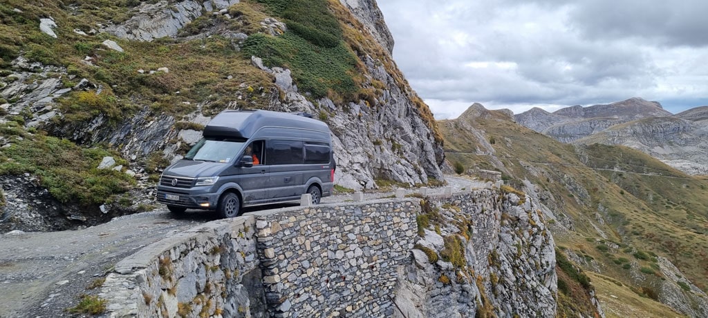 Ein grauer Campervan auf einer Bergstraße