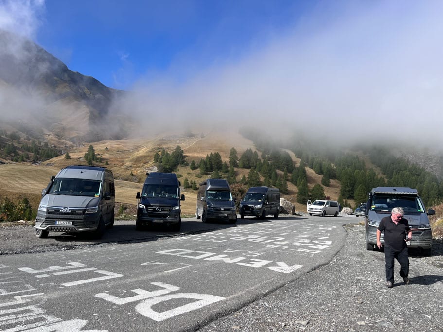 Campingfahrzeuge und ein Mann auf einem Parkplatz im Gebirge