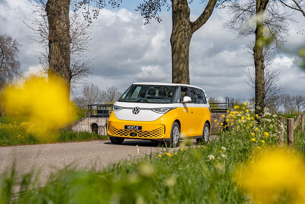 Leuchtend gelb und weiß lackierter VW ID. Buzz auf einer Straße