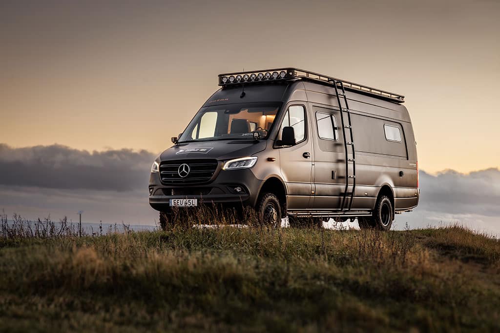 Dunkler Mercedes-Benz Sprinter mit Leiter an der Seite