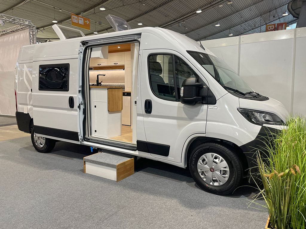 CMT 2025 Campervan-Neuheiten: Weißer Kastenwagen mit Campingausbau in einer Messehalle