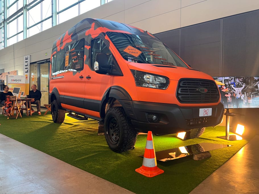 Offroad-Camper CMT 2025: Grell-orangefarbener Allrad-Kastenwagen in einer Messehalle