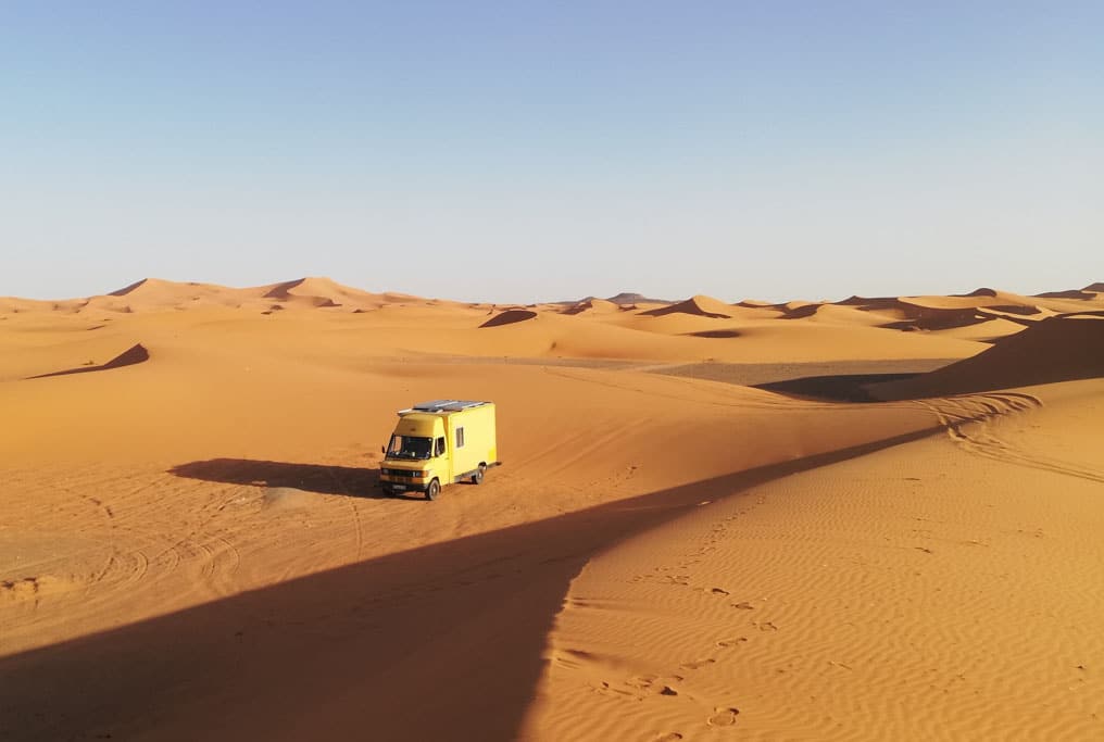 Gelber Postbus in Wüstenlandschaft