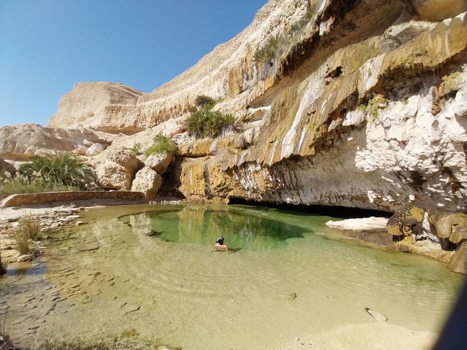 Ein flaches Wasserbassin am Fuße eines hohen Felsens