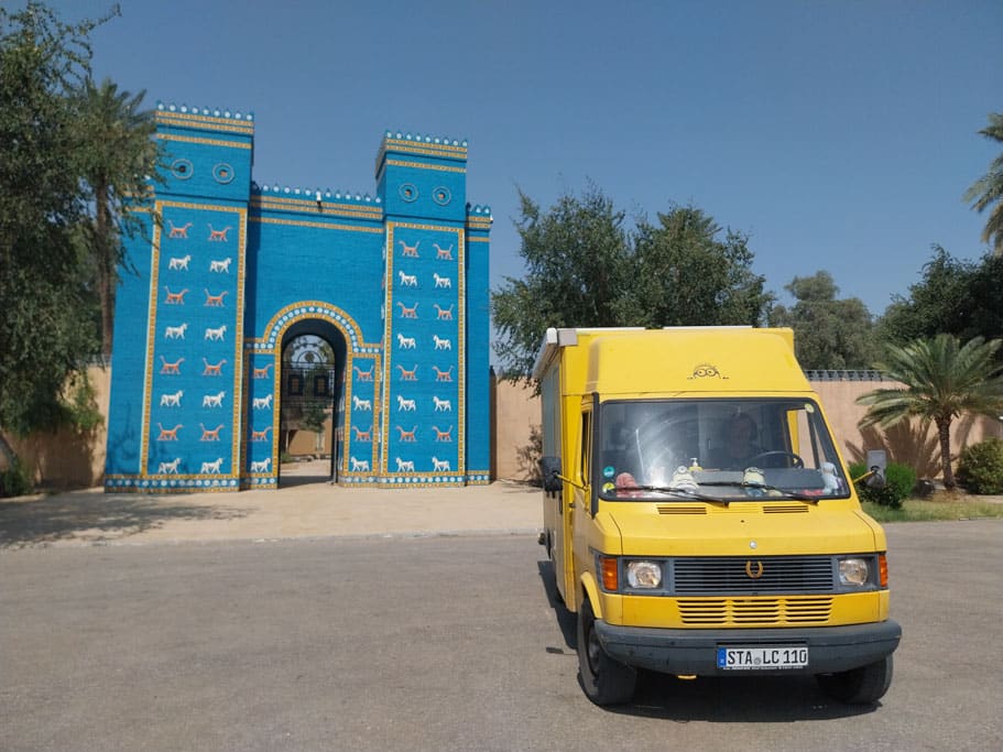 Gelber Postbus vor hellblauem Gebäude